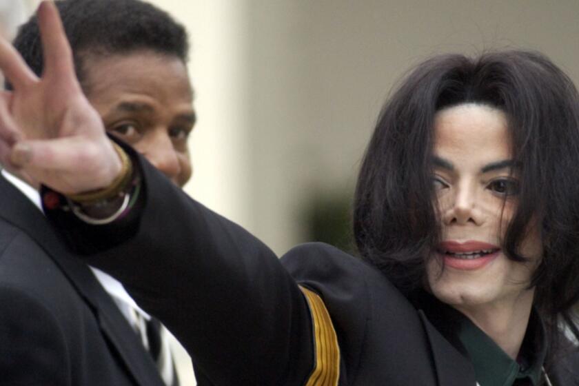 FILE - In this March 2, 2005 file photo, pop icon Michael Jackson waves to his supporters as he arrives for his child molestation trial at the Santa Barbara County Superior Court in Santa Maria, Calif. The estate of Michael Jackson on Thursday sued HBO over a documentary about two men who accuse the late pop superstar of molesting them when they were boys, saying the film violates a 1992 contract to air a Jackson concert. The lawsuit filed in Los Angeles County Superior Court alleges that by co-producing and airing "Leaving Neverland," the cable channel is committing breach of contract and breach of covenant, citing a section of the deal for ?Michael Jackson in Concert in Bucharest: The Dangerous Tour? that states HBO would not disparage Jackson at the time or in the future. (AP Photo/Michael A. Mariant, File)