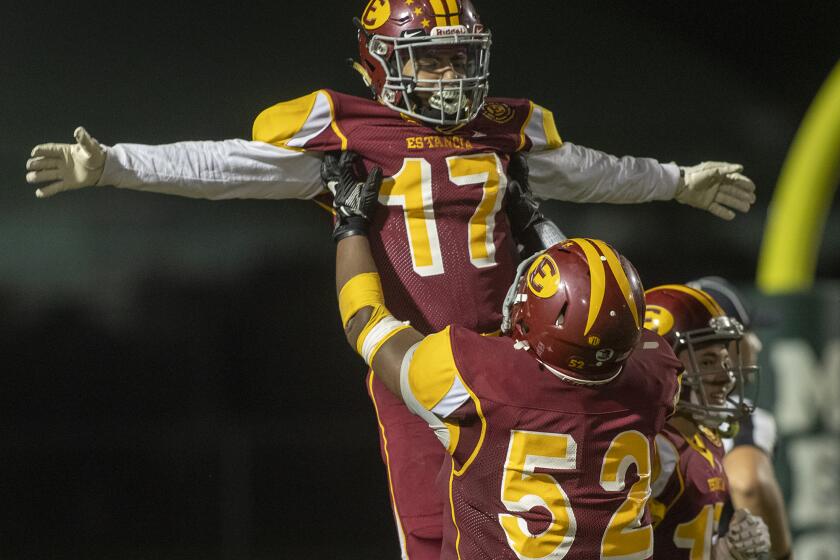 Estancia's Margarito Olivera lifts Beto Sotomayor in the air in celebration after Sotomayor scored a touchdown in the first half against Saddleback during an Orange Coast League game at Cost Mesa High School on Friday, October 10.