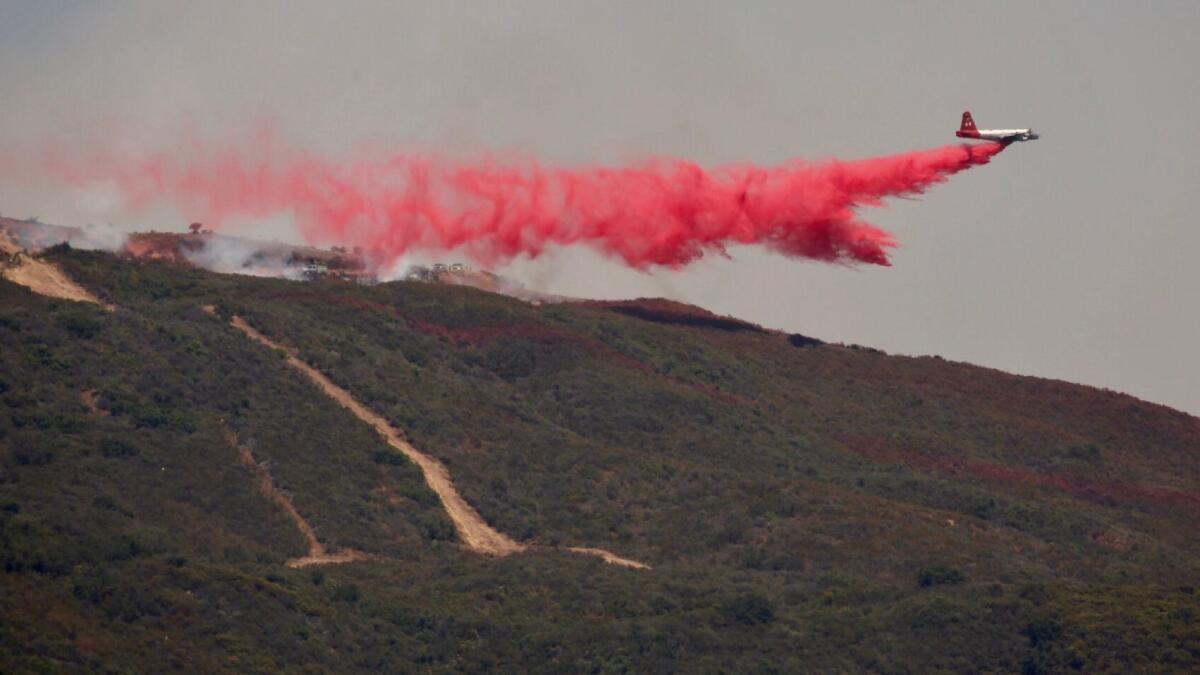 Fixed-wing aircraft drop flame retardant on the Whittier fire in Goleta.