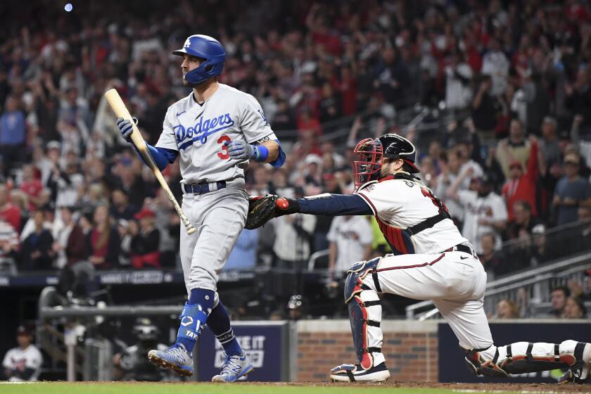 Atlanta Braves catcher Travis d'Arnaud, right, tags out Los Angeles Dodgers' Chris Taylor after Taylor struck out