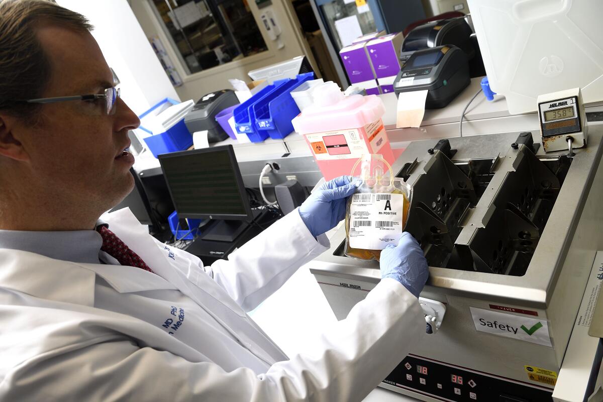 A Johns Hopkins pathologist holds a bag of donated COVID-19 convalescent plasma.