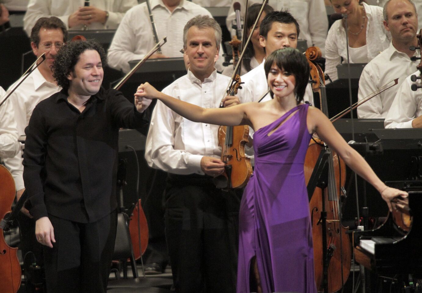 Conductor Gustavo Dudamel, left, concertmaster Martin Chaulifer, center, and piano soloist Yuja Wang, right, at the L.A. Phil's performance at the Hollywood Bowl on Aug. 9, 2012. More: Yuja Wang turns heads at the Hollywood Bowl with a purple gown Photos