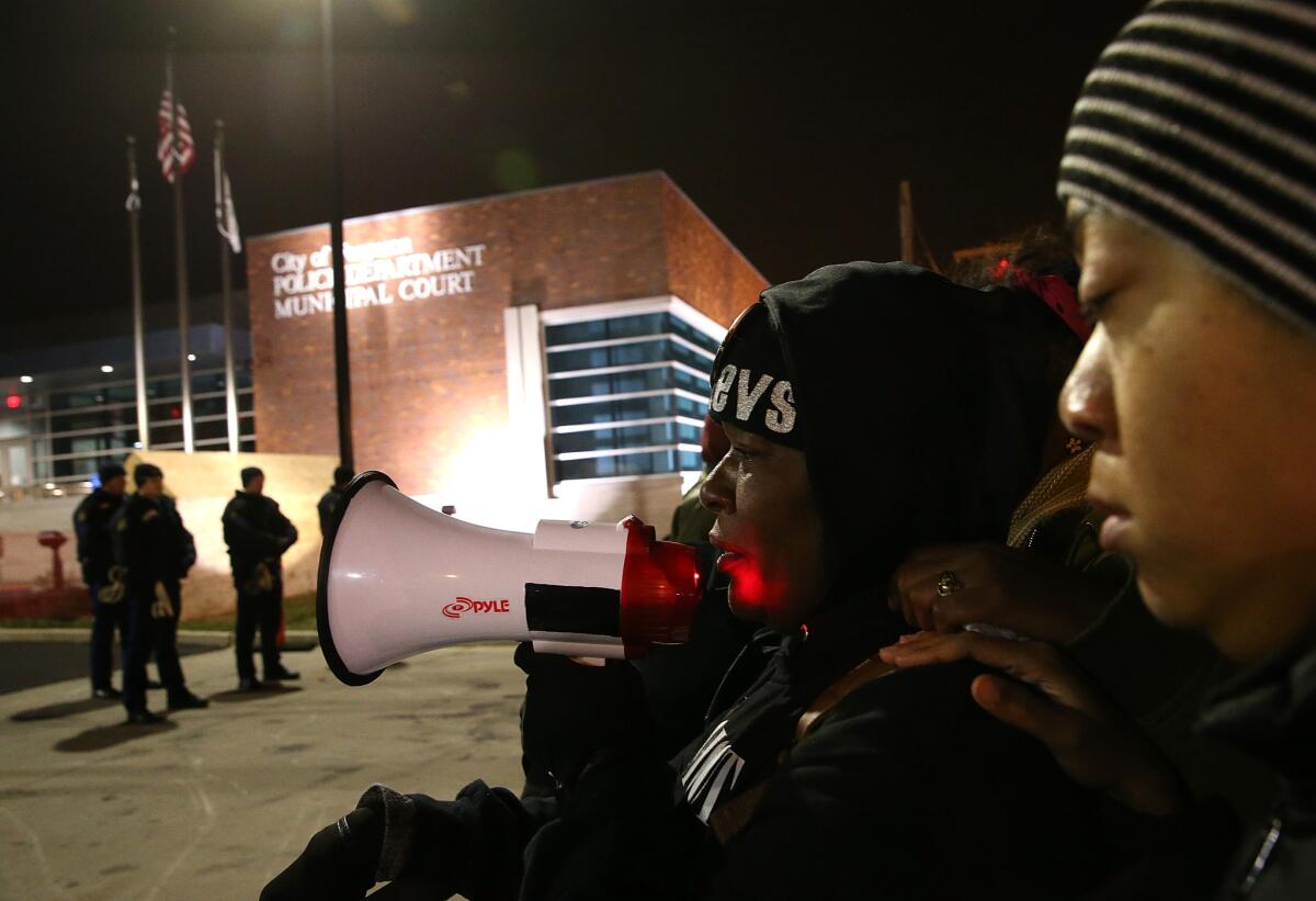 A demonstrator cries as she pleads for peace in front of the Ferguson Police Department on Monday night.