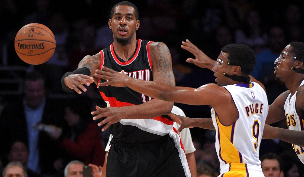 Trail Blazers forward LaMarcus Aldridge is forced to pass while under pressure from Lakers guard Ronnie Price (9) and forward Ed Davis in the first half.