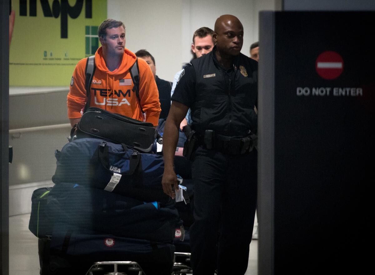 Jack Conger, left, and Gunnar Bentz are escorted through Miami International Airport after arriving back in the U.S. on Friday.