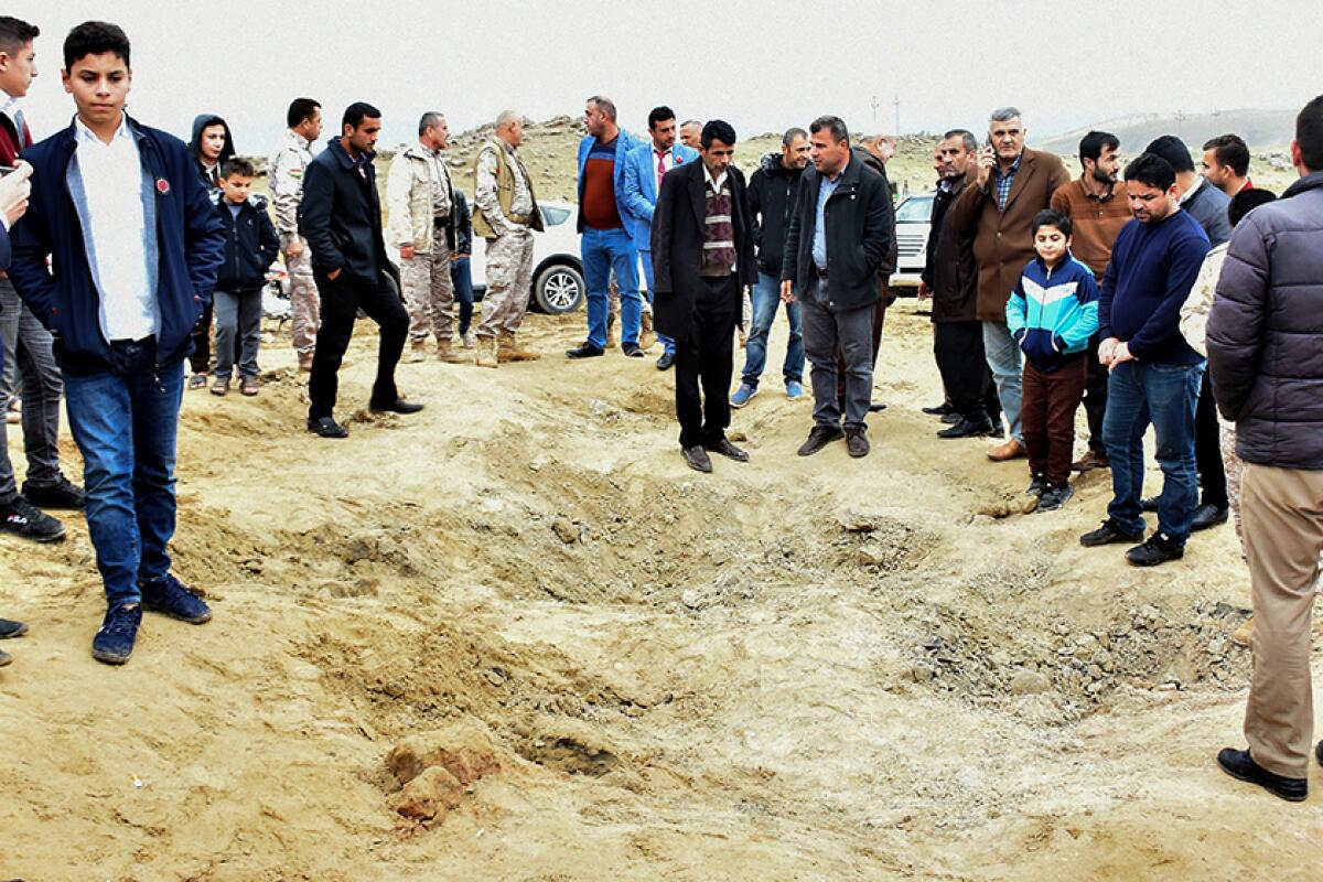 In the Iraqi Kurdish town of Bardarash, people gather around a crater said to have been caused by one of the Iranian missiles.