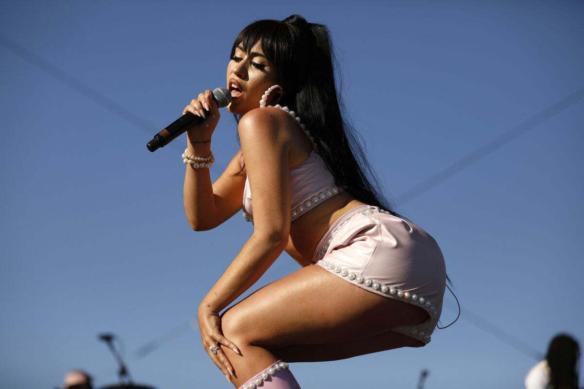  Kali Uchis holds a microphone as she sings at Coachella in 2018.