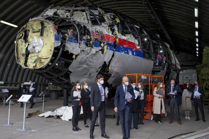 FILE - Judges and lawyers view the reconstructed wreckage of Malaysia Airlines Flight MH17, at the Gilze-Rijen military Airbase, southern Netherlands, on May 26, 2021. (AP Photo/Peter Dejong, Pool)