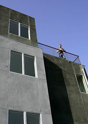 Designer Mathew Mitchell stands on the balcony of a three-story duplex near downtown L.A. that he built with designer Tim Campbell. The back-to-back units have about 500 square feet of living space on each floor and city skyline views. (Christine Cotter./.LAT)