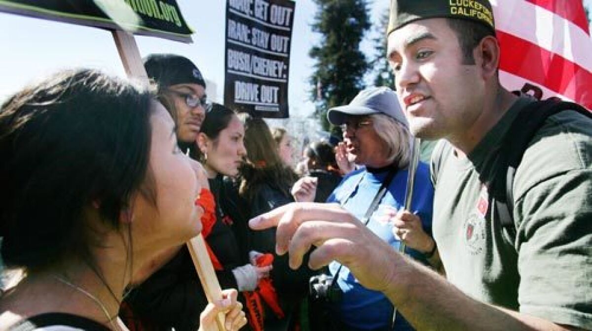 Javier Tenorio, right, a junior at UC Berkeley who served nearly two years in Iraq with the Army, talks with a student protester near Berkeley City Hall. The City Council tonight will consider a motion to rescind its criticism of military recruiting techniques and the Marine Corps, which drew a firestorm of protest.