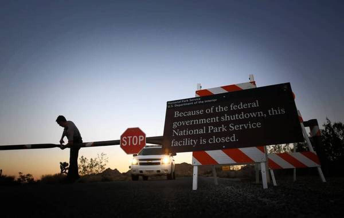 Park ranger Mike Shuman locks the western entrance to Joshua Tree National Park, closed due to the impasse in Congress over the federal budget.
