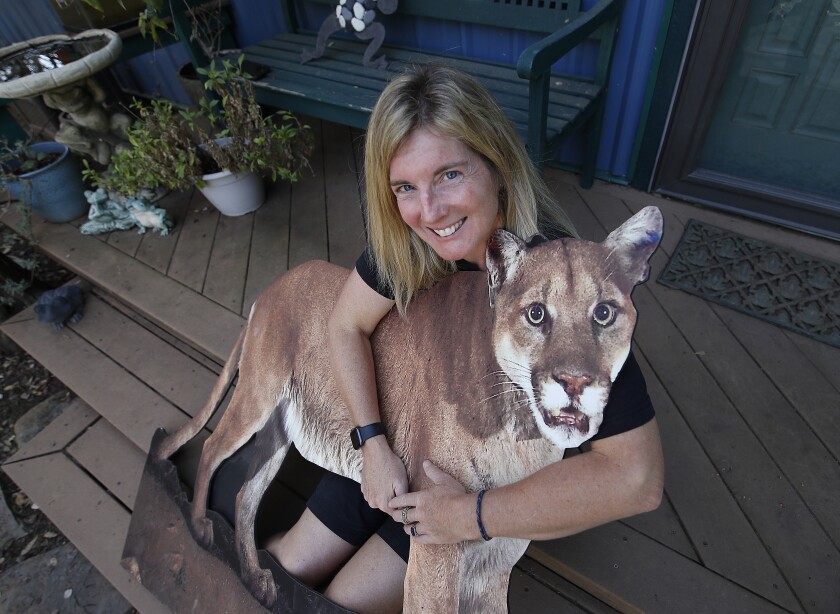 Beth Pratt holds a cutout of a mountain lion