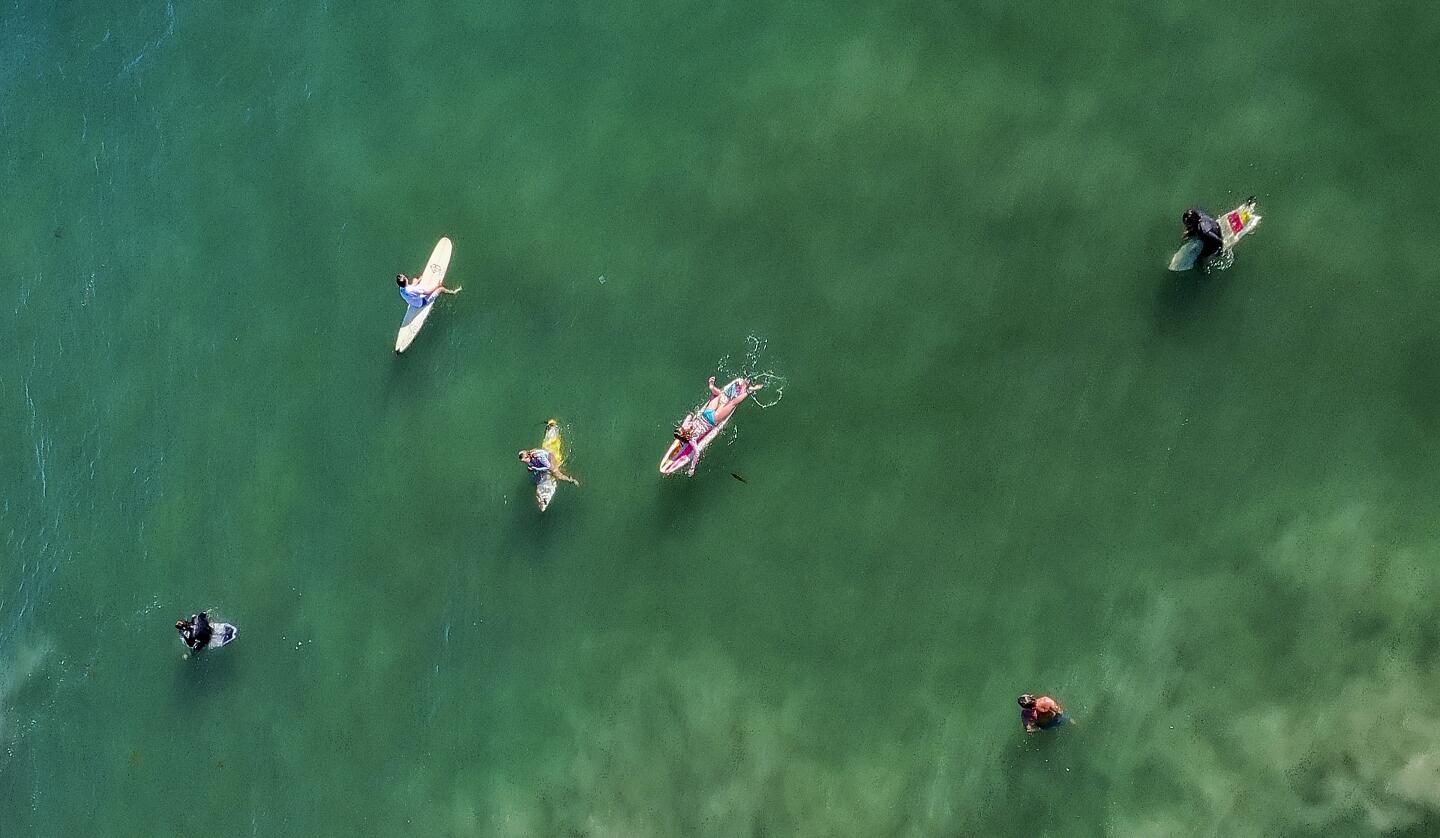 Aerial view shows surfers waiting for a wave in Newport Beach