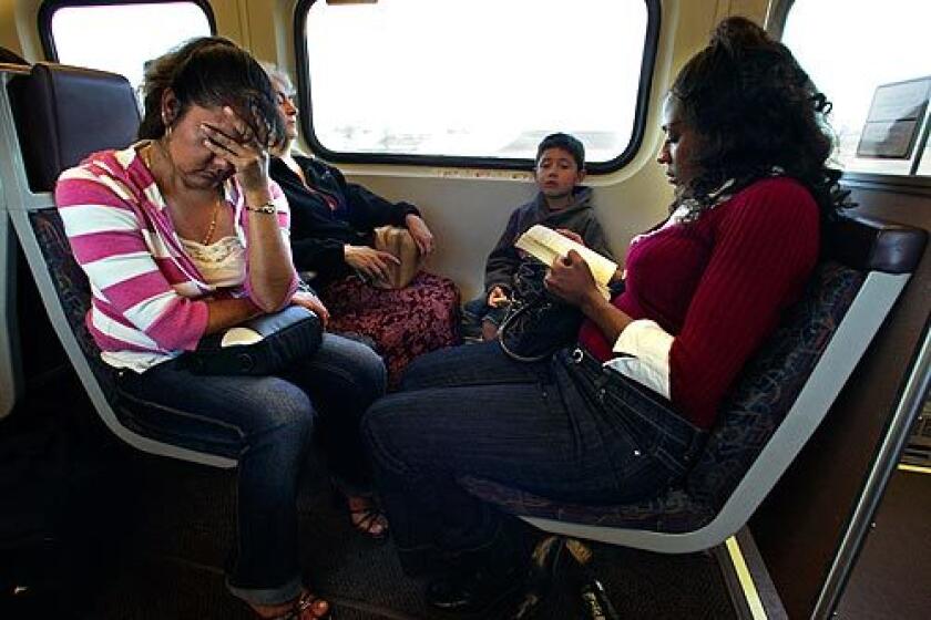 Aundraya Ross-Reliford, right, reads on the Metrolink train that takes her from Rialto to downtown L.A.
