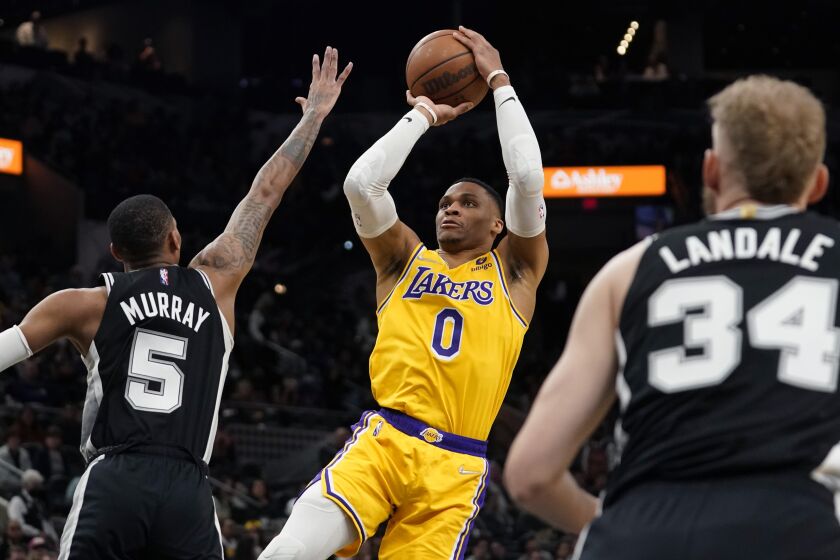 Los Angeles Lakers guard Russell Westbrook (0) shoots over San Antonio Spurs guard Dejounte Murray (5) during the first half of an NBA basketball game, Monday, March 7, 2022, in San Antonio. (AP Photo/Eric Gay)