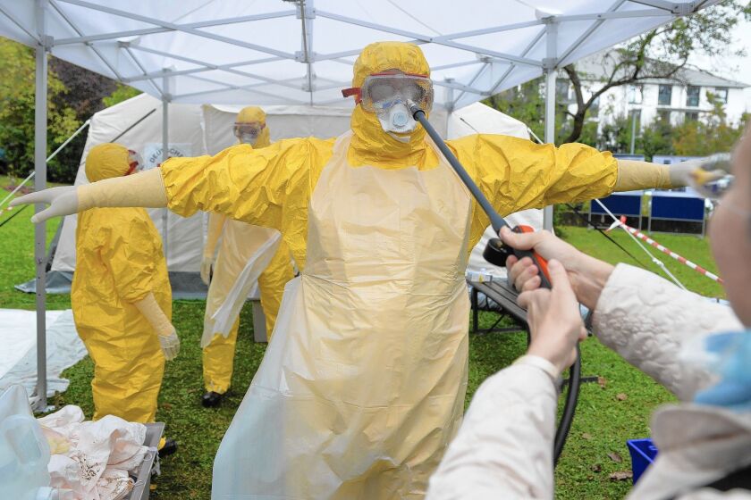 A doctor who has volunteered to travel to West Africa to help care for Ebola patients is disinfected during training offered by the German Red Cross in Wuerzburg.