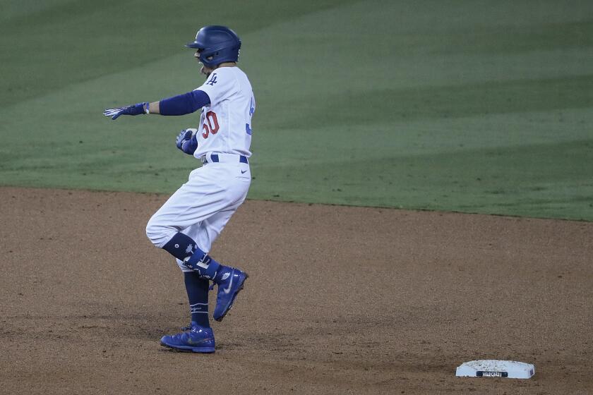 The Dodgers' Mookie Betts celebrates after hitting a two-run double against the Milwaukee Brewers on Oct. 1, 2020.