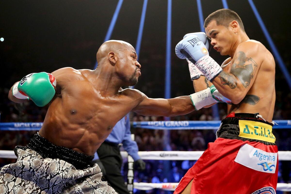Floyd Mayweather Jr. lands a jab to the body of Marcos Maidana in their welterweight title fight on Saturday night at the MGM Grand Garden Arena in Las Vegas.