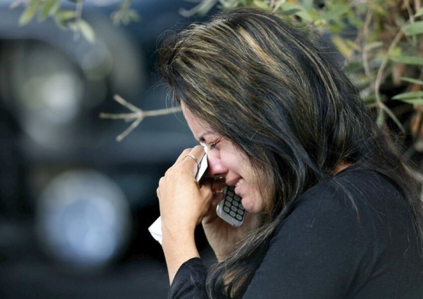 A woman who said she is Flor Medrano's friend weeps while talking on the phone as police investigate Medrano's death and the police shooting death of the man who killed her. Medrano had filed a domestic abuse report several hours earlier.