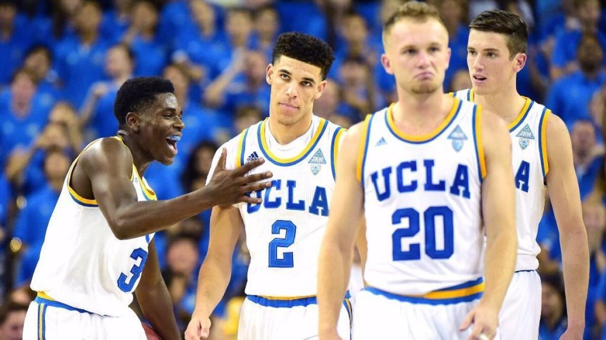 Aaron Holiday (3) pats Lonzo Ball (2) on the chest following his dunk against Pacific during the first half of a game on Nov. 11.