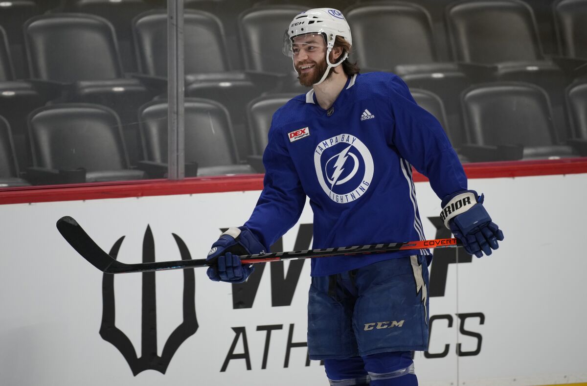 Tampa Bay Lightning center Brayden Point jokes with teammates as he takes the ice during an NHL hockey practice before Game 1 of the Stanley Cup Finals against the Colorado Avalanche, Tuesday, June 14, 2022, in Denver. (AP Photo/David Zalubowski)