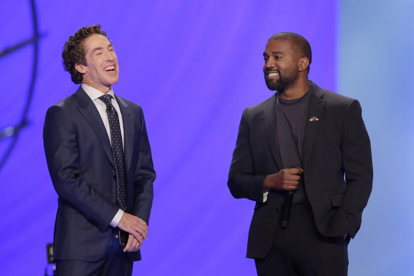 Kanye West, right, answers questions from senior pastor Joel Osteen, left, during a service at Lakewood Church on Nov. 17, 2019 in Houston.