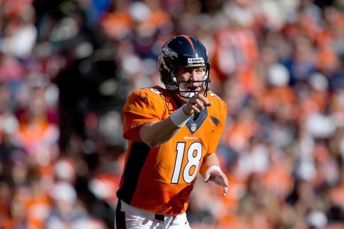 Broncos quarterback Peyton Manning changes a play at the line of scrimmage during a game against the Redskins.