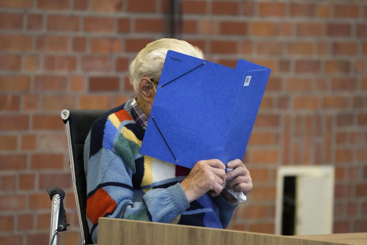 The accused Josef S. covers his face as he sits at the court room in Brandenburg, Germany, Thursday, Oct. 7, 2021. The 100-year-old man charged as an accessory to murder on allegations that he served as a guard at the Nazis' Sachsenhausen concentration camp during World War II. (AP Photo/Markus Schreiber)