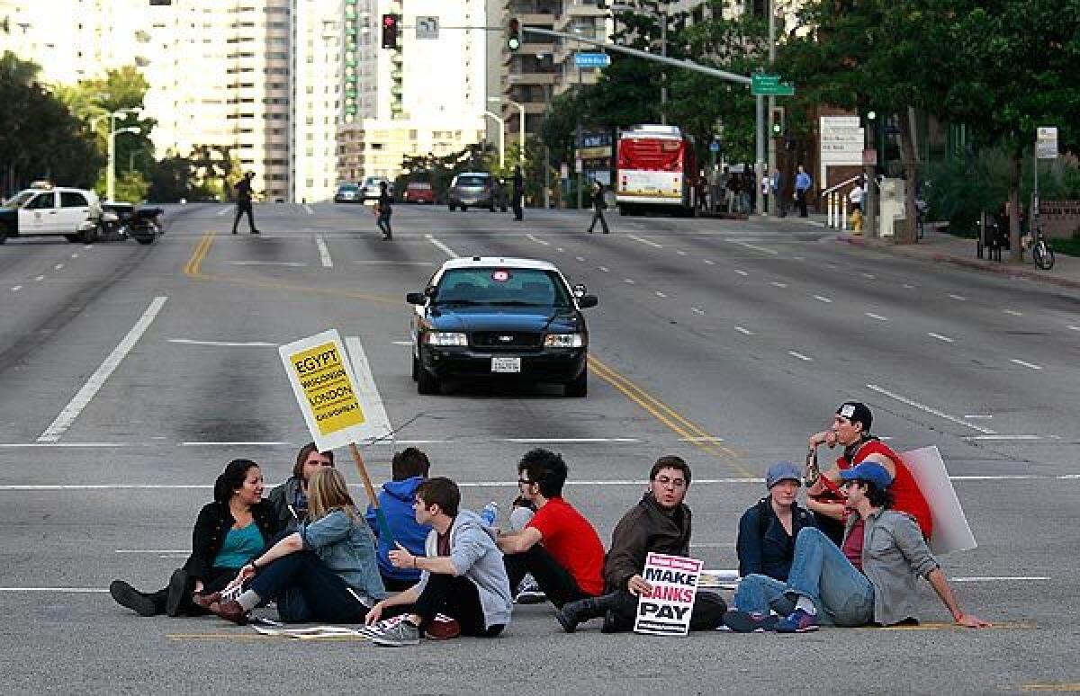 UCLA students sit in the middle of the intersection of Wilshire and Westwood boulevards, where traffic was shut down for hours Wednesday. Eleven people were arrested on suspicion of failing to disperse.