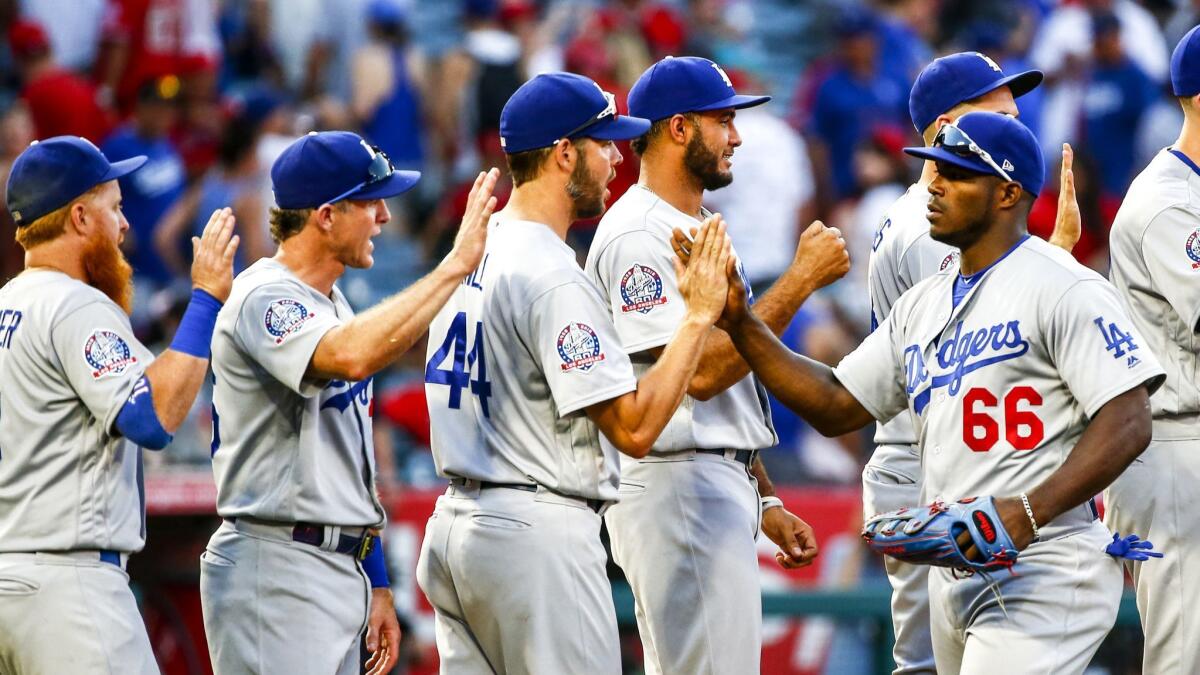 Dodgers right fielder Yasiel Puig (66) and his teammates celebrate their win over the Angels at Angel Stadium on Saturday.