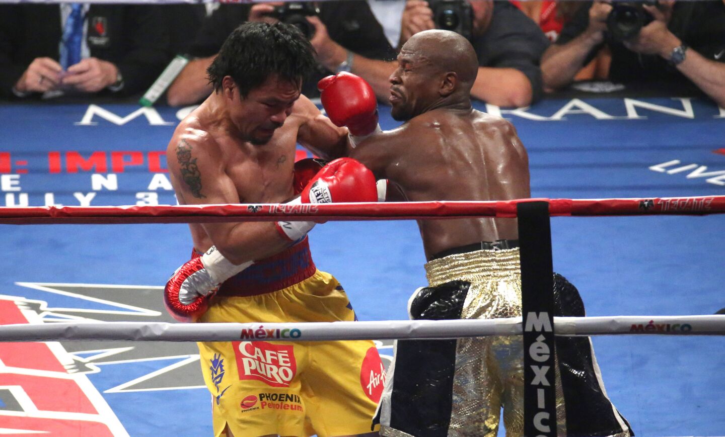 Floyd Mayweather Jr., right, trades blows with Manny Pacquiao.
