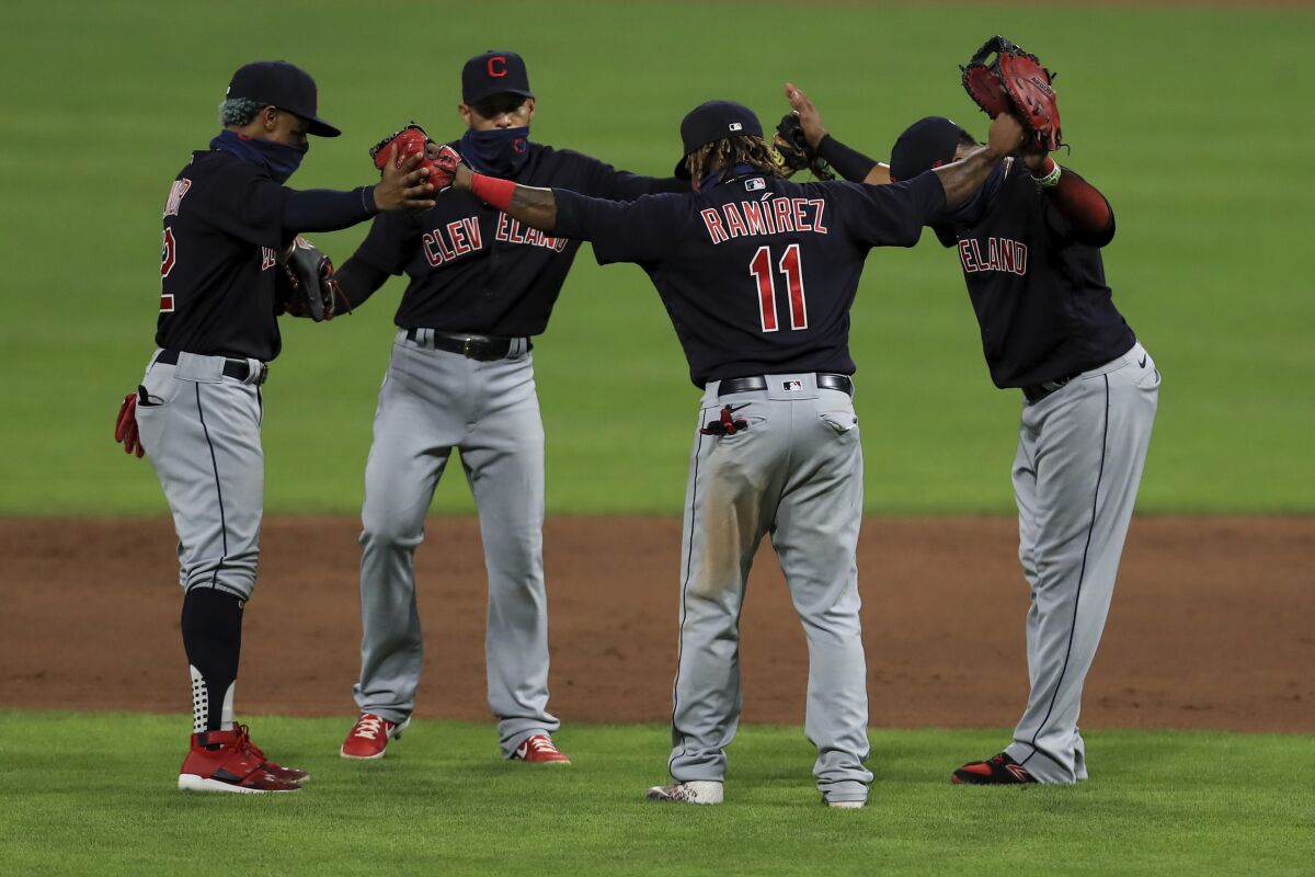 Cleveland Indians' Francisco Lindor, left, Cesar Hernandez, middle left, Carlos Santana, right, and Jose Ramirez, middle right, celebrate after a baseball game against the Cincinnati Reds in Cincinnati, Tuesday, Aug. 4, 2020. The Indians won 4-2. (AP Photo/Aaron Doster)