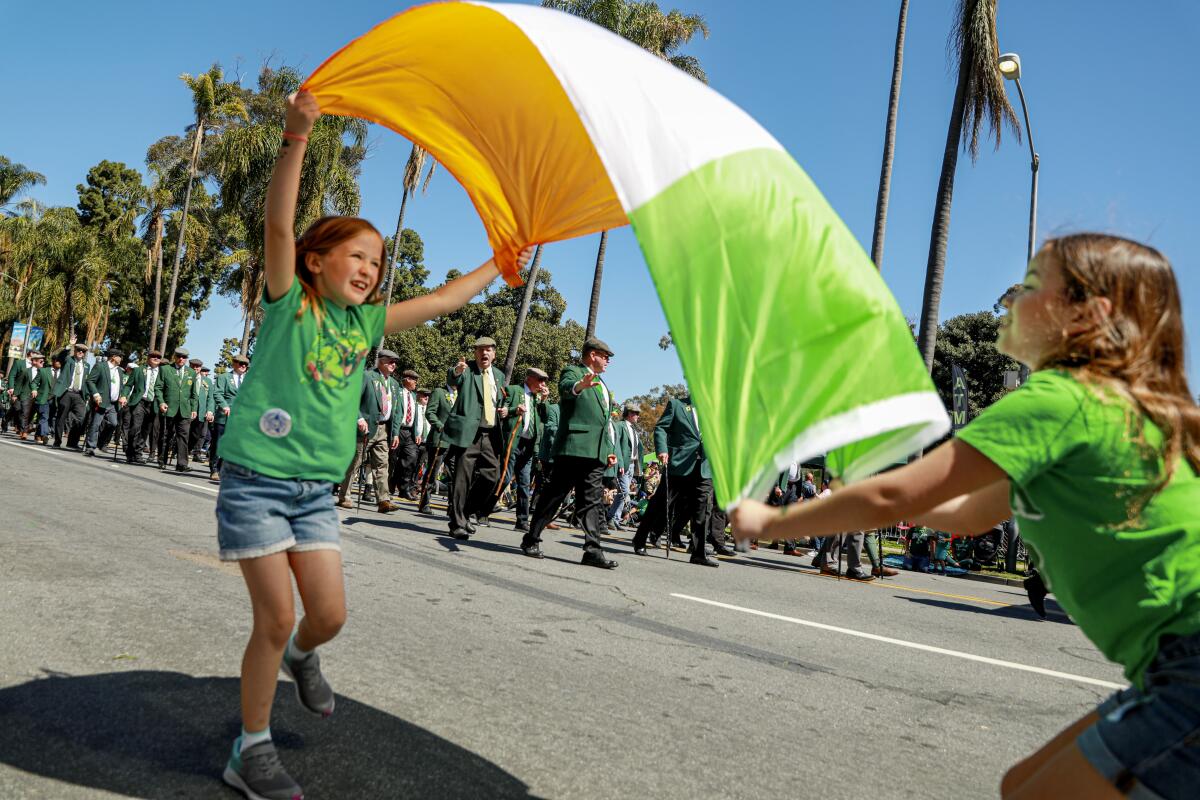 Christina Byrne,7, and Erin Karran, 8, wave an Irish flag for parade performers.