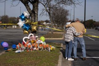 Debbie, left, and Chet Barnett place flowers at a memorial outside of the Chesapeake, Va., Walmart on Thursday, Nov. 24, 2022. Andre Bing, a Walmart manager, opened fire on fellow employees in the break room of the Virginia store, killing six people in the country’s second high-profile mass shooting in four days, police and witnesses said Wednesday. (Billy Schuerman/The Virginian-Pilot via AP)