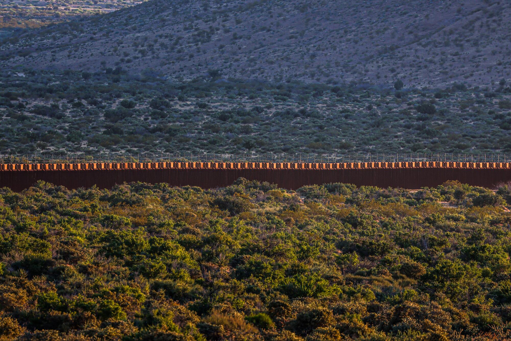 The border wall glows in late afternoon sunlight