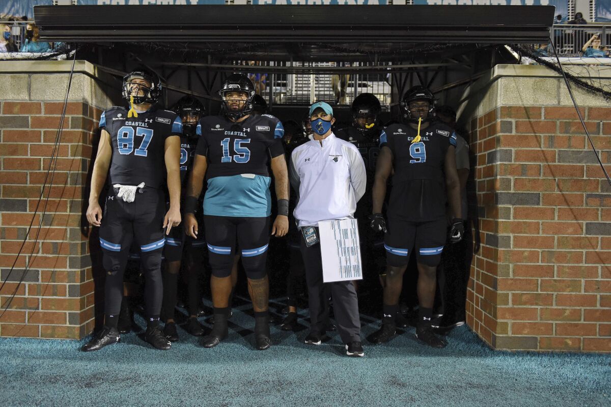 Coastal Carolina head coach Jamey Caldwell, second from right, waits with his team to take the field before an NCAA college football game against South Alabama, Saturday, Nov. 7, 2020, in Conway, S.C. (AP Photo/Richard Shiro)