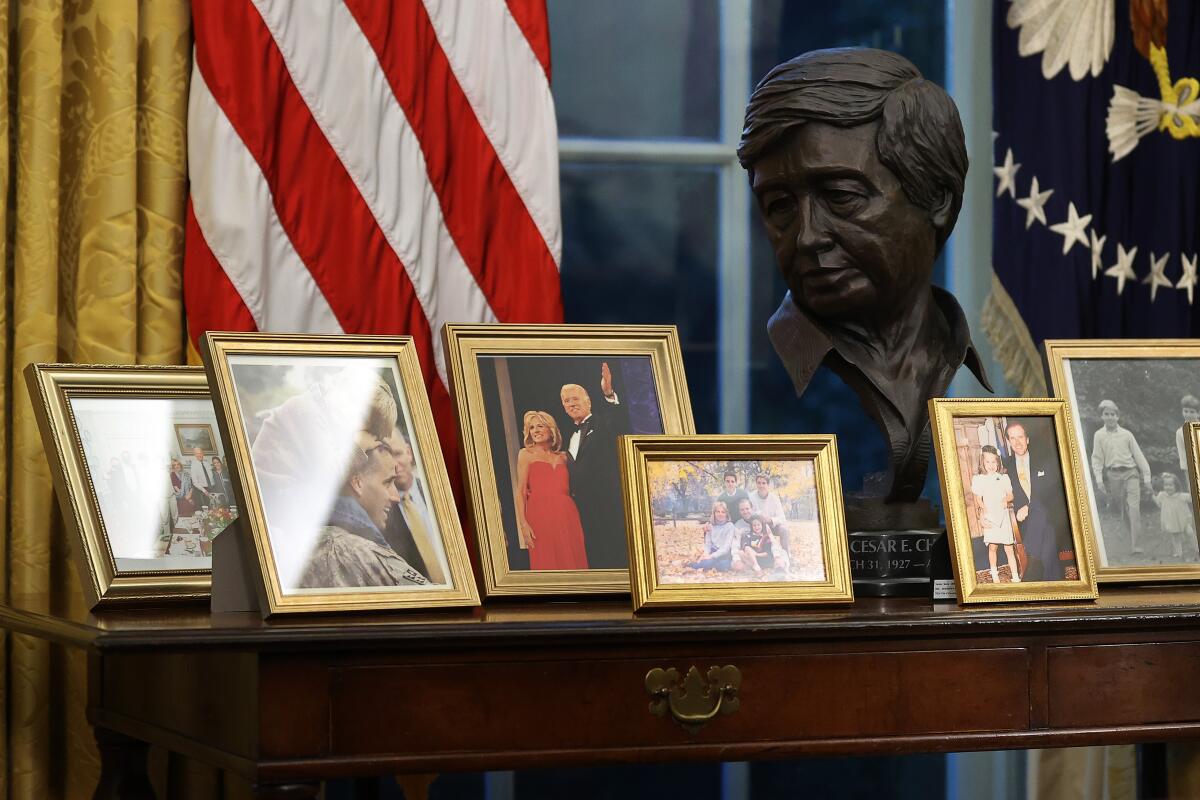 A bust of Cesar Chavez is surrounded by photos of Joe Biden's family 