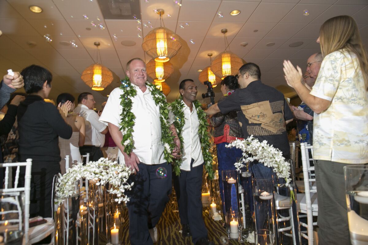 Guests applaud Shaun Campbell, left, and Tony Singh after their wedding at the Sheraton Waikiki in Honolulu.