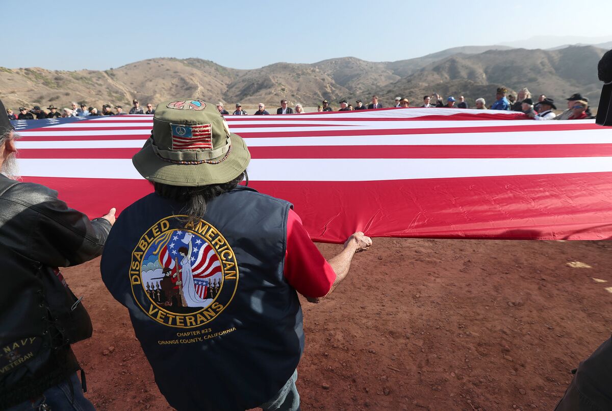 Veterans and local officials unfurl "Flag One" at the proposed veterans cemetery in Anaheim Hills.