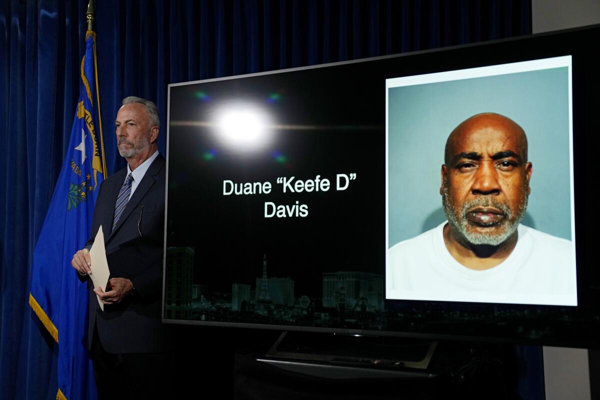 Clark County District Attorney Steve Wolfson stands beside a photo of Duane "Keefe D" Davis