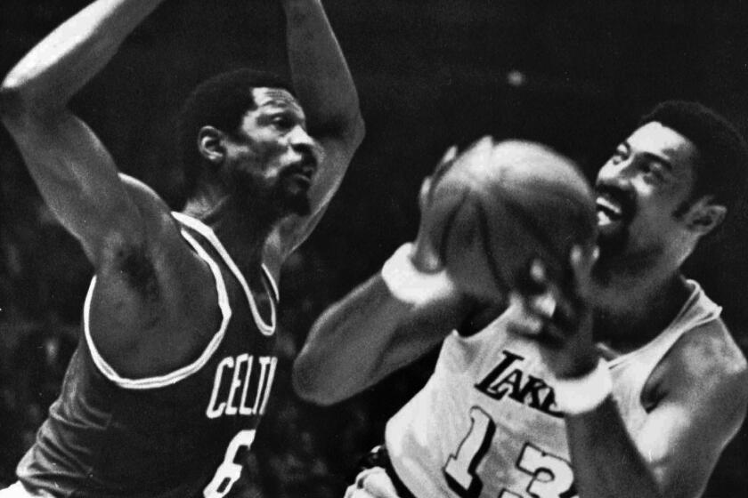 FILE - Los Angeles Lakers' Wilt Chamberlain tries to shoot against Boston Celtics' Bill Russell.