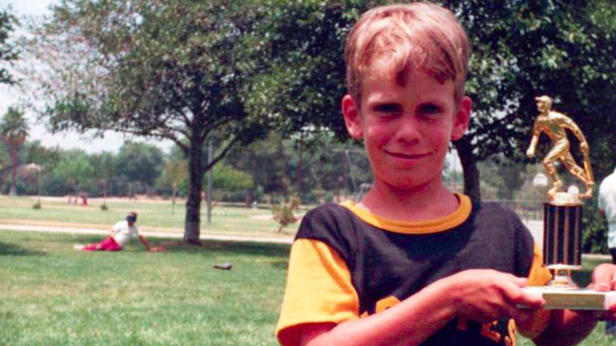 In a snapshot from 1973, Bruce, then 8, displays the Little League trophy he won with the San Fernando Valley Pirates. The trophy would later be a weapon.