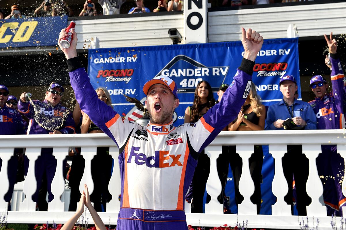 Denny Hamlin celebrates after winning Sunday's NASCAR Cup race at Pocono Raceway.