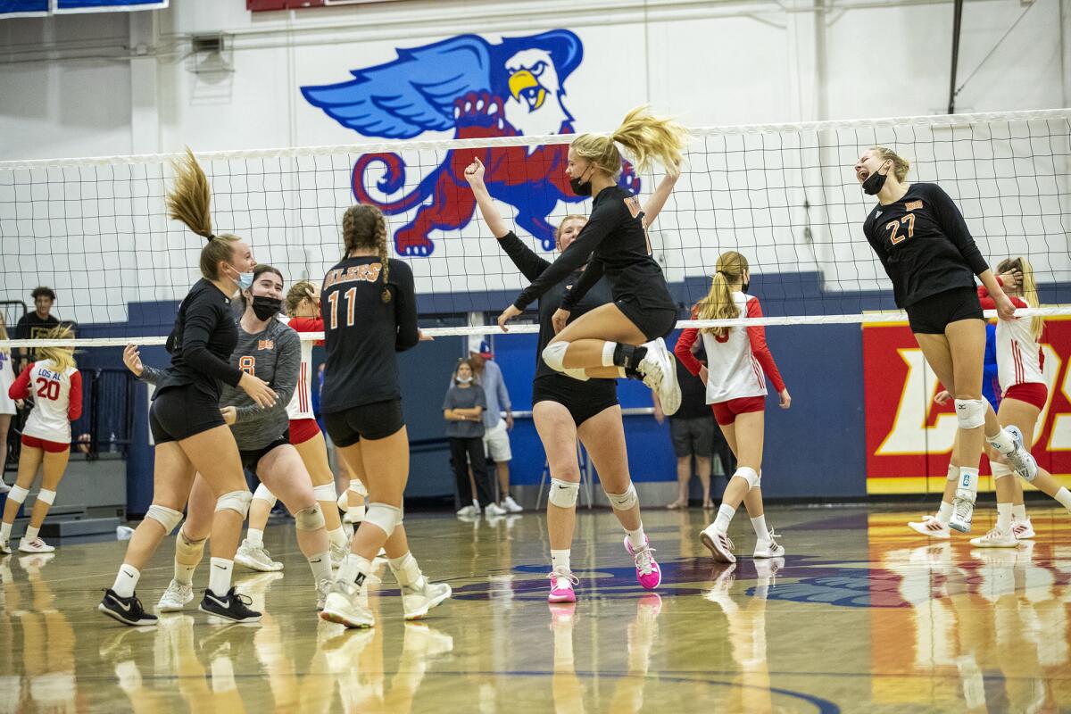 The Huntington Beach girls' volleyball team celebrates after sweeping Los Alamitos during a Surf League match on Tuesday.