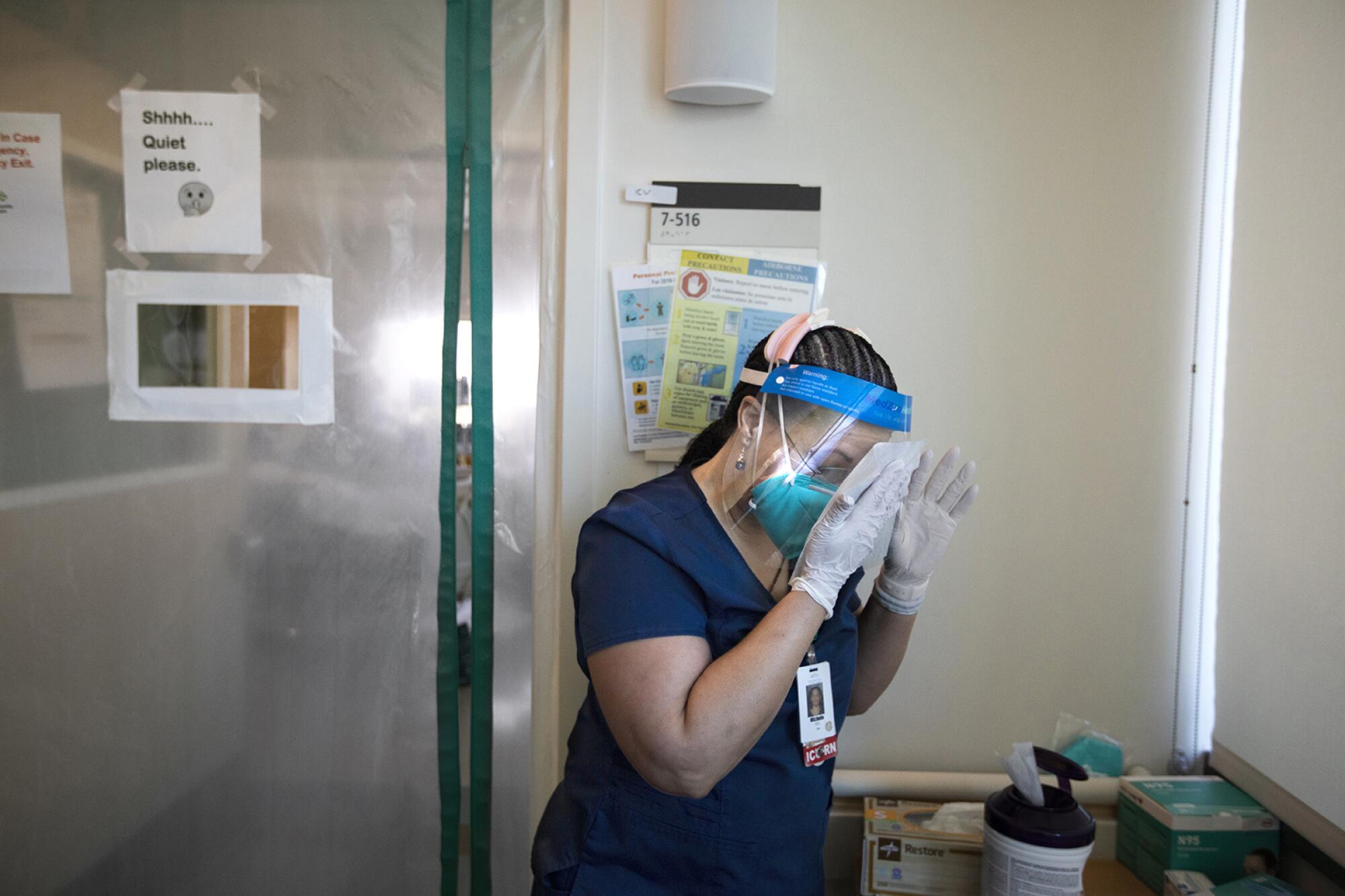 Nurse Michelle Goldson cleans her face shield