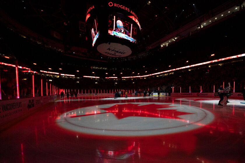 A maple leaf is projected on the ice during the singing of the Canadian national anthem at Rogers Arena in Vancouver.