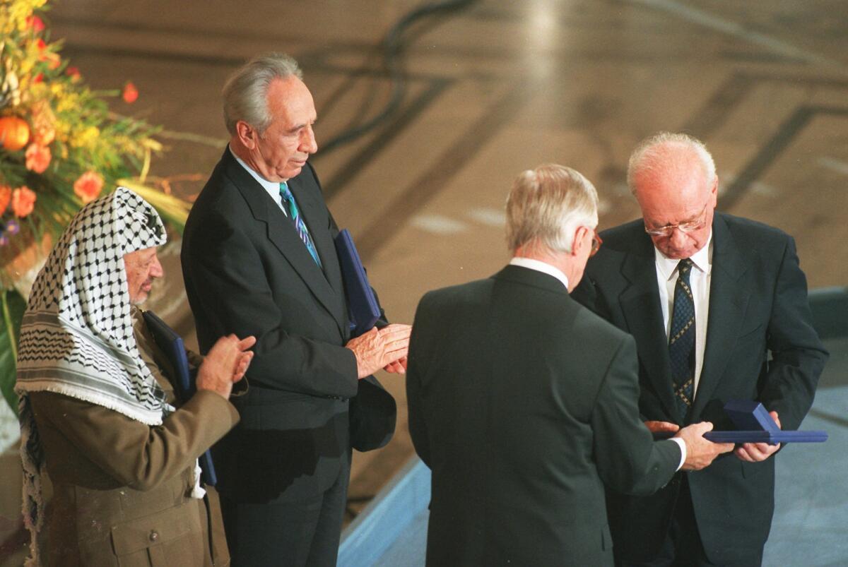 Palestine Liberation Organization Chairman Yasser Arafat, left, Israeli Foreign Minister Shimon Peres, Israeli Prime Minister Yitzhak Rabin, right, receive the 1994 Nobel Peace Prize in Oslo's City hall on Dec. 10, 1994.