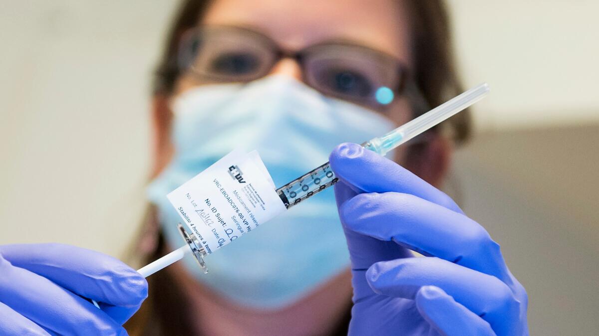 A nurse holds a dose of an experimenta Ebola vaccine.