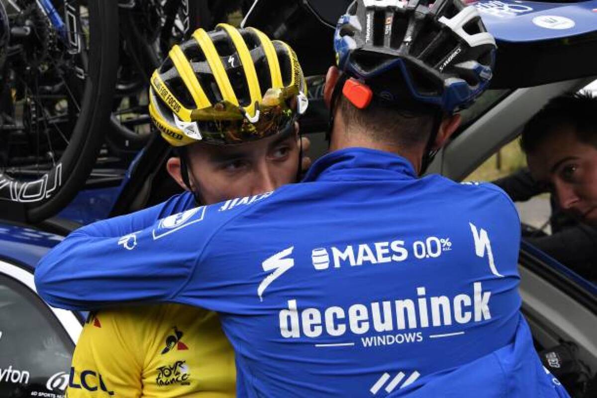 France's Julian Alaphilippe is comforted by a teammate after losing his yellow jersey Friday during the storm-shortened Stage 19 of the Tour de France.
