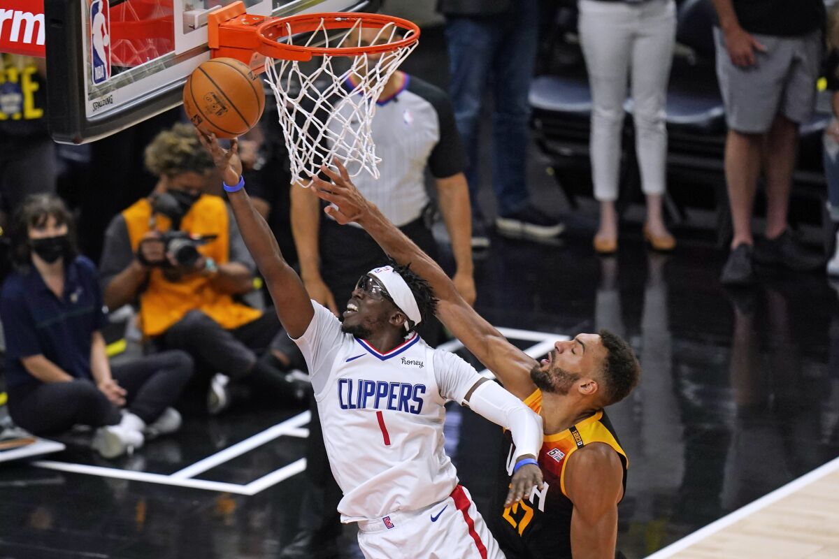 FILE - Los Angeles Clippers guard Reggie Jackson (1) goes to the basket as Utah Jazz center Rudy Gobert, right, defends during the second half of Game 5 of a second-round NBA basketball playoff series in Salt Lake City, in this Wednesday, June 16, 2021, file photo. Reggie Jackson is returning to the Los Angeles Clippers after helping the team reach the Western Conference finals for the first time. The team announced the re-signing of the free-agent point guard on Wednesday, Aug. 11, 2021. (AP Photo/Rick Bowmer, File)